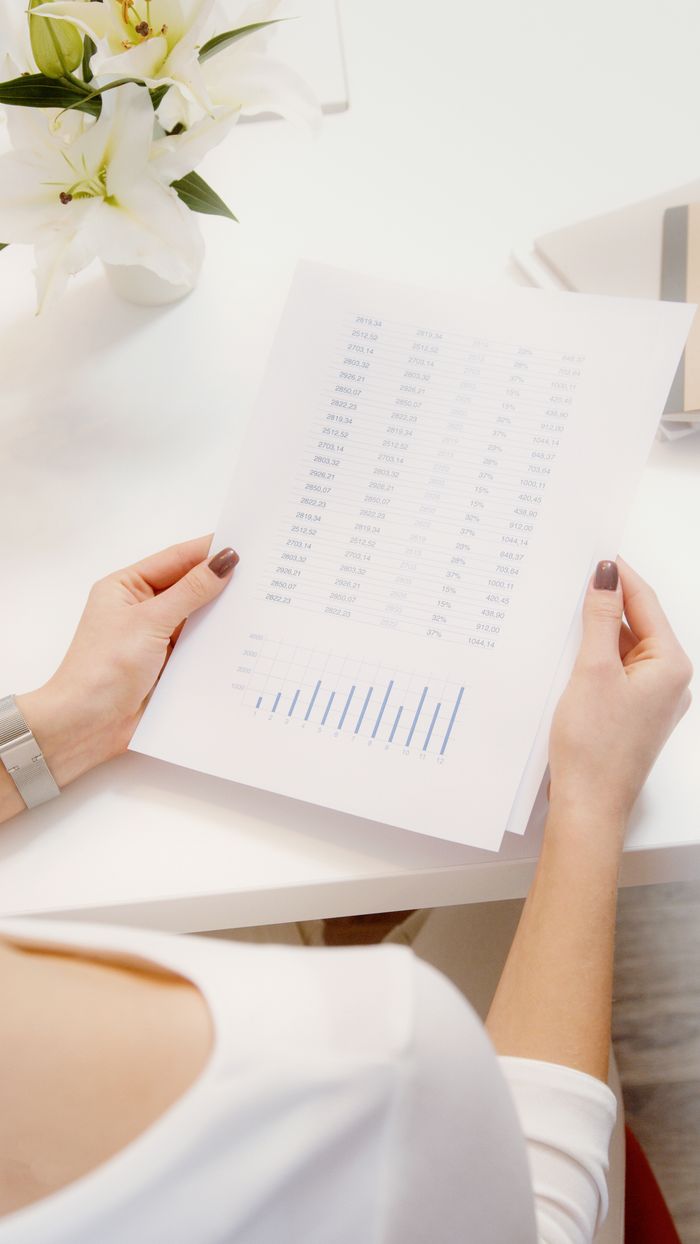 our-experience An overhead view of a person reviewing financial documents with graphs.
